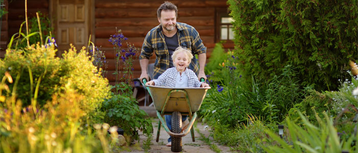 father driving son in wheel barrel